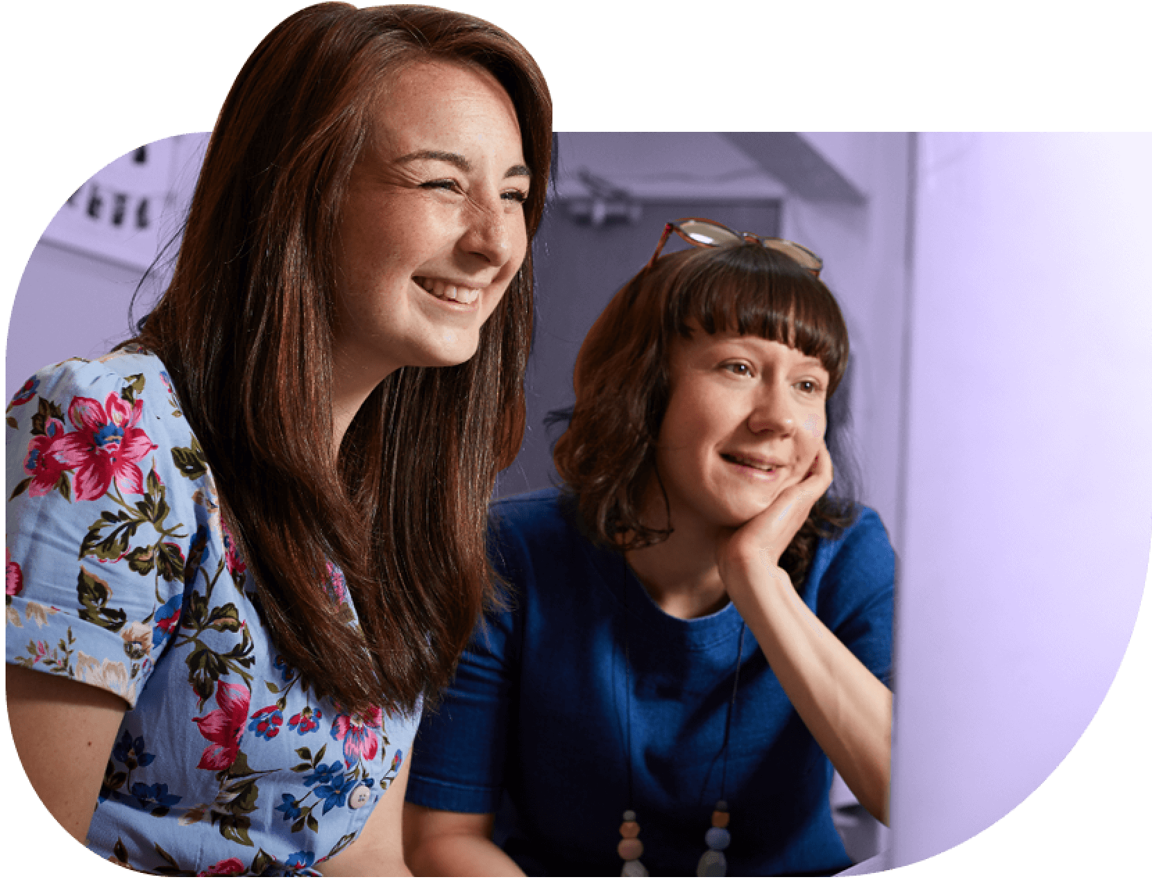 Faye Savory, BearHugs social enterprise founder smiles with another colleague. Faye has long brown hair and wears a floral dress.